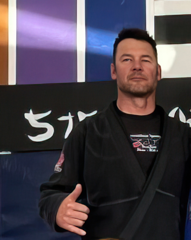 Brett Shaw, Brazilian Jiu-Jitsu coach, giving a thumbs up at the gym